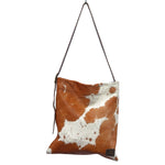 Brown Cowhide Messenger Bag, in a chestnut cow print, with a crossbody strap and yellow velvet lining.