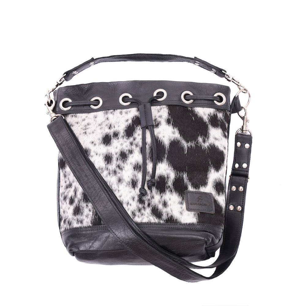Ethically-made, cow print, leather bucket bag featuring distinctive cowhide front and leather back