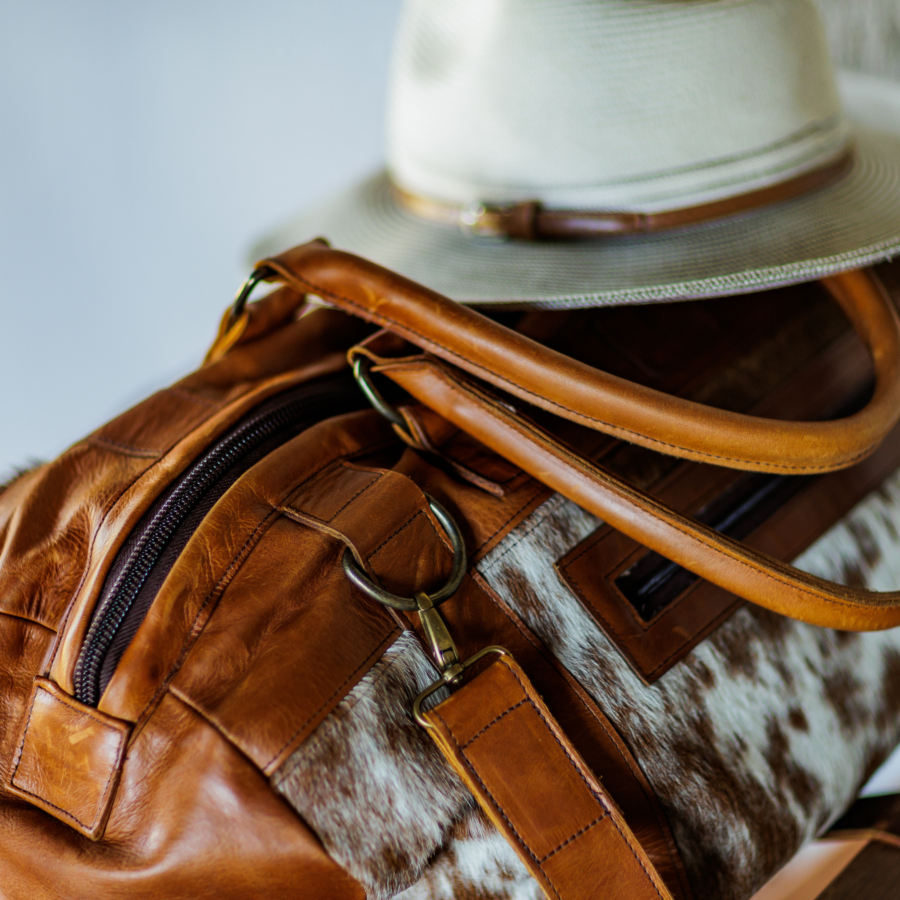 Close-up view of the cowhide weekend travel bag, highlighting its premium leather, spacious design, and luxurious suede lining