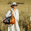 Woman wearing a large brown and white cowhide bag with brown leather straps