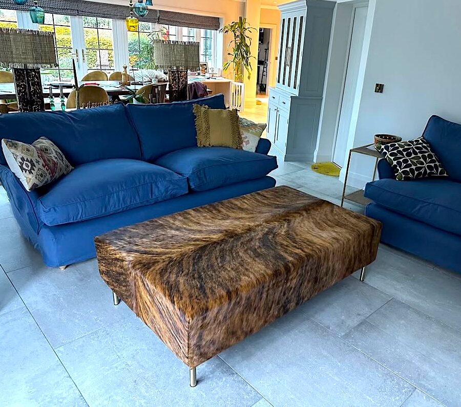 modern bespoke cowhide footstool in a sitting room