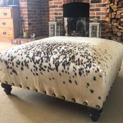 cowhide footstool in sitting room by the fire