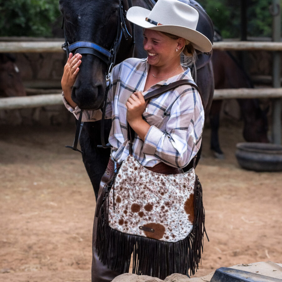 Cow print cowhide fringe bag – handmade, stylish, and empowering Zulu artisans.