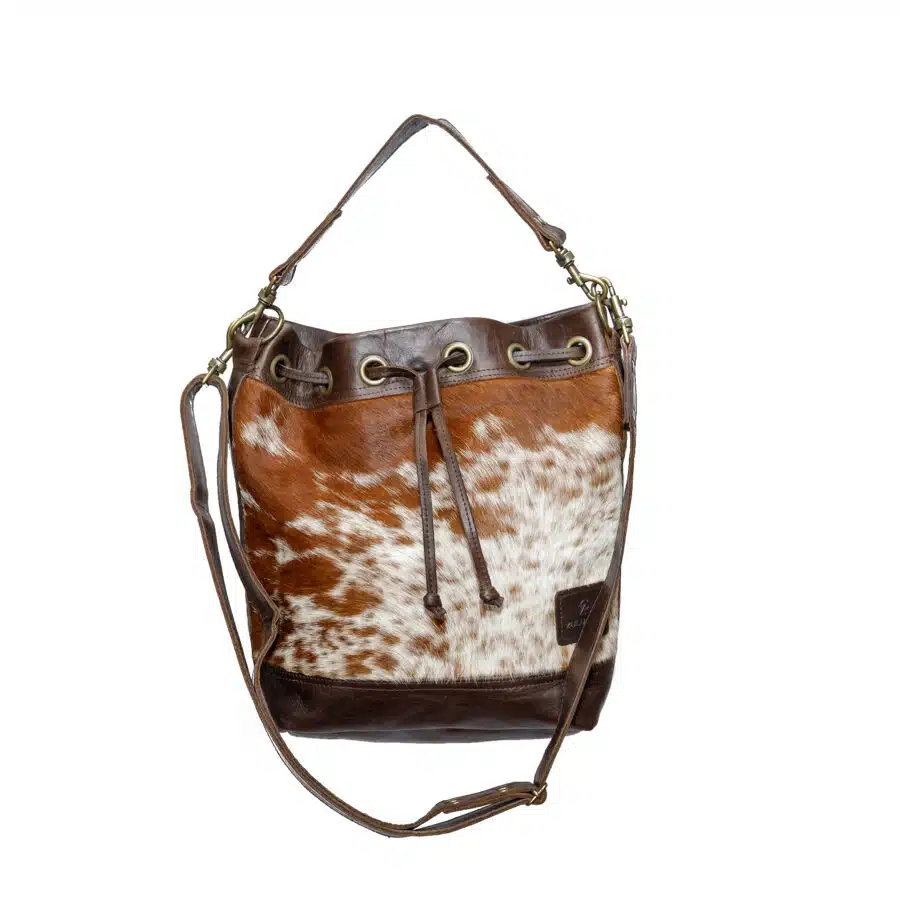 Ethically-made, cow print, leather bucket bag featuring distinctive cowhide front and leather back