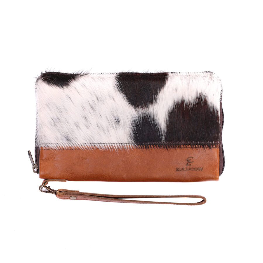 Ethically made cowhide travel wallet featuring multiple compartments and on trend with this year's cow print fashion