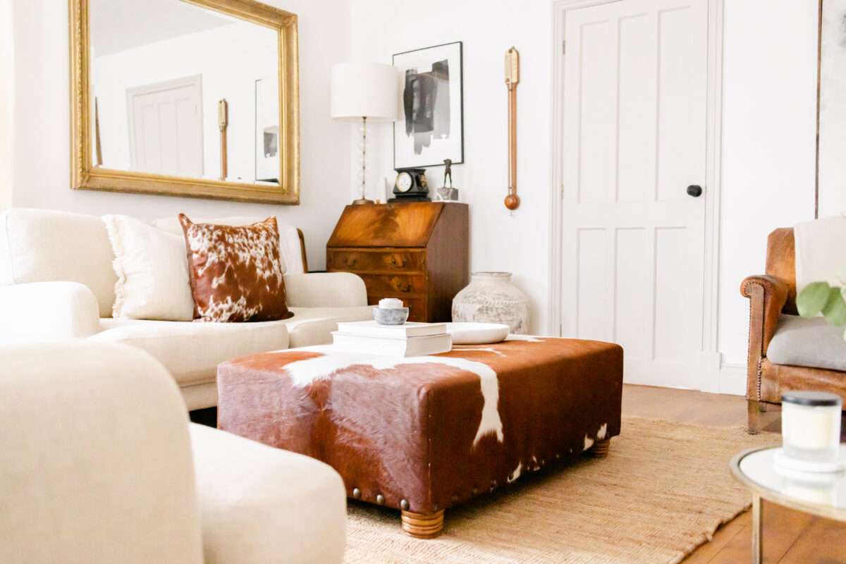 Bespoke brown and white Nguni cowhide ottoman, ethically sourced from South Africa, with natural markings and sustainable craftsmanship