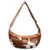 Ethically made cow print cowhide sling bag with adjustable leather strap and top zip closure
