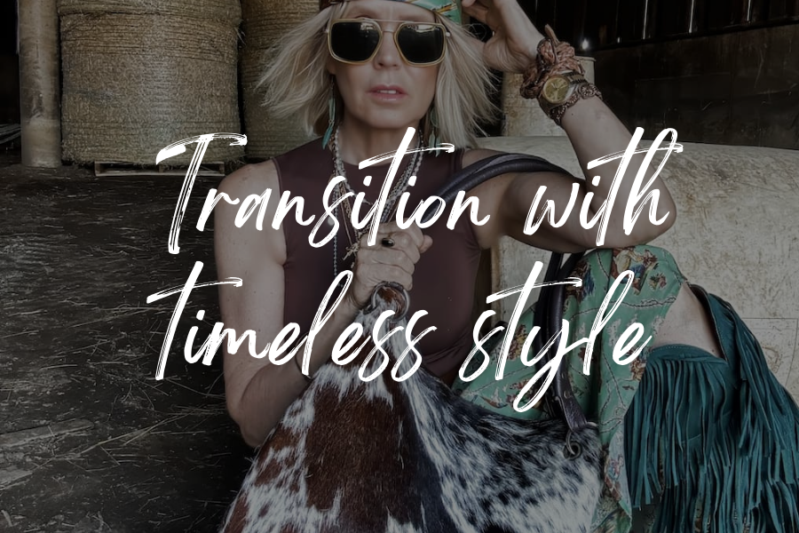 A model poses in a barn with a Nguni cowhide bag. Overlay text reads "transition with timeless style"