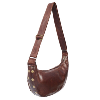 Ethically made cow print cowhide sling bag with adjustable leather strap and top zip closure