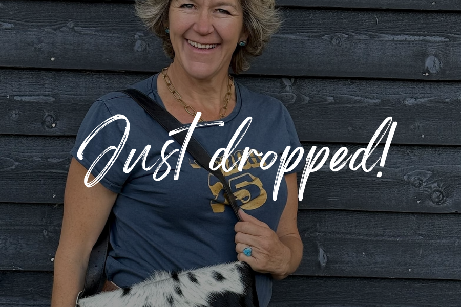 Lucy with black and white cowhide bag. Text reads: just dropped!
